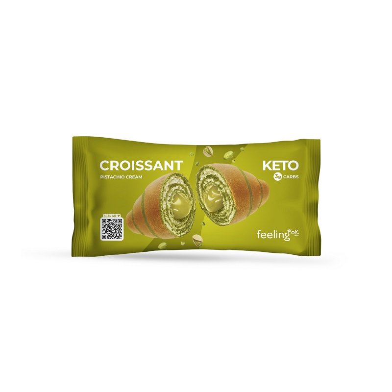 Croissant Keto FeelingOK al Pistacchio Confezione di croissant keto FeelingOK tagliato a metà con visibile ripieno cremoso al pistacchio su sfondo verde.